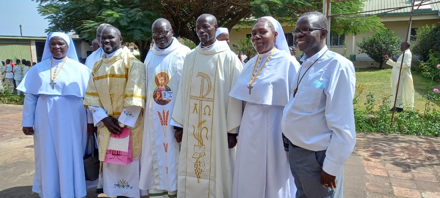 Newly ordained Fr. Albert Kitaga in cream and Deacon Ubaldo Inziku Dragon